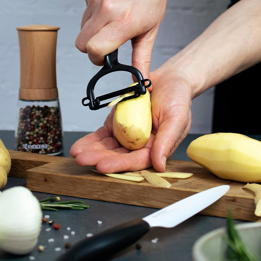 KYOCERA keramický nůž na ovoce a zeleninu s bílou čepelí 11 cm, černá rukojeť + škrabka na ovoce a zeleninu